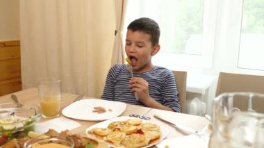 Çocuk çatalla et yiyor. Yakın plan.