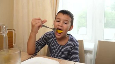 Çatalla meyve yiyen bir çocuk. Yakın plan.