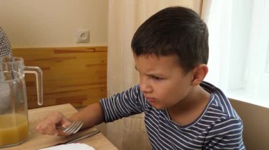 Çatalla meyve yiyen bir çocuk. Yakın plan.