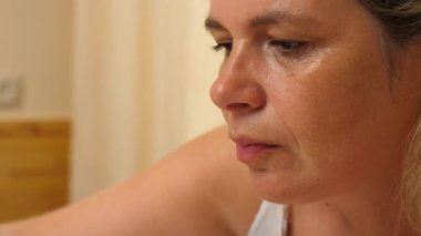 Masada otururken çatalla meyve yiyen bir kadın. Yakın plan.