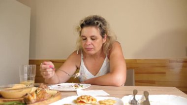 Masada otururken sebze yiyen bir kadın. Yakın plan..