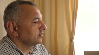 Profildeki adam masada çatallı şeftali yiyor, yemek sırasında odaklanmış ve sakin..