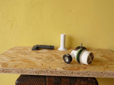 Plastik lavabo boşaltma mekanizması parçaları ahşap tahtaya yerleştirilmiş sarı arkaplan