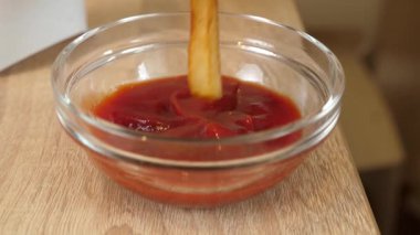 Çocuk elinin cam kaseye patates kızartması bandırması..