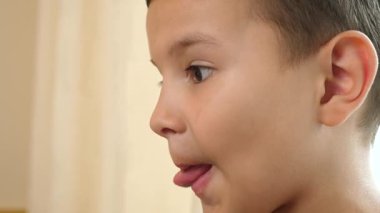 Çocuk evde atıştırırken patates kızartması yiyor ve kızarmış yemeğin tadını çıkarıyor..