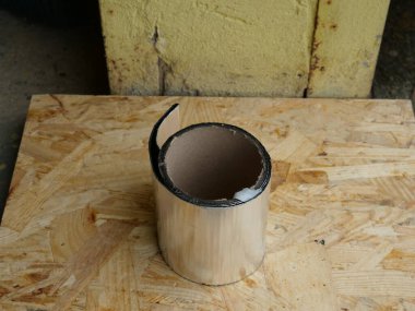 Atölyedeki OSB tahtasında duran karton silindirik tüp...