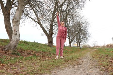 Parkta sabah egzersizi yapan bir kadın.