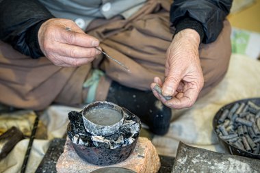 An artisan at the Korean folk Village in Yongin, Korea works his craft of weaving