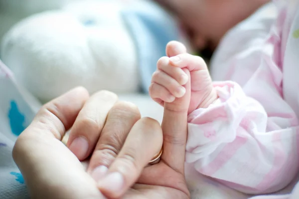 Mãe mão segurando o bebê. Foto tirada no ginecológico neonatal — Fotografia de Stock
