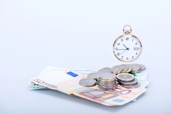 Relógio de bolso com notas e moedas de euro — Fotografia de Stock