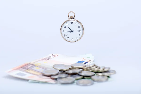 Кишеньковий годинник з євро банкнотами та монетами — стокове фото
