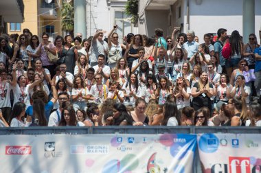 Aktörler mavi halı üzerinde bekleyen çocuklar