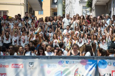 Aktörler mavi halı üzerinde bekleyen çocuklar