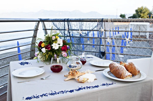 romantic breakfast by the sea with croissants, juice and flowers