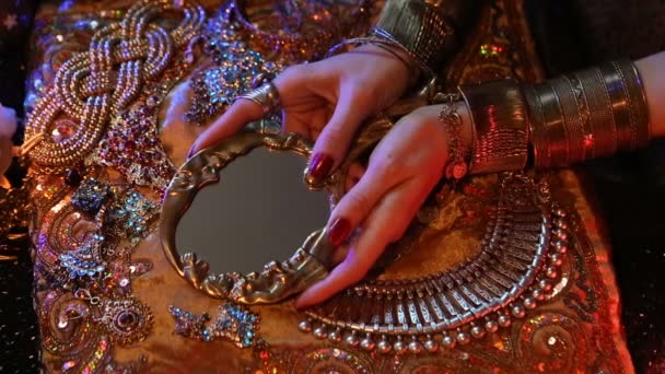 Goldener orientalischer Schmuck und Accessoires: Frauenhände mit Schmuck und Spiegel. — Stockvideo