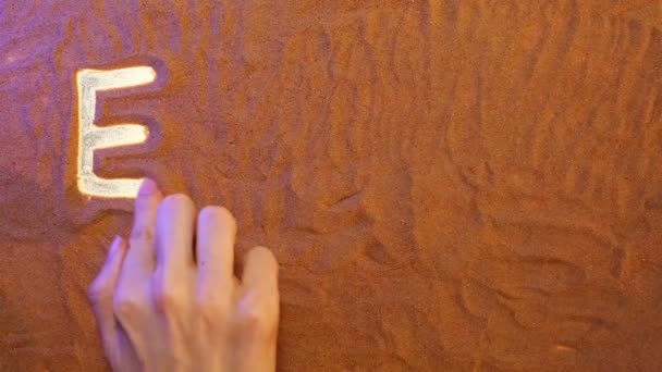 Hand zeichnet ägyptisches Symbol in den Sand. Strand Hintergrund. Ansicht von oben — Stockvideo