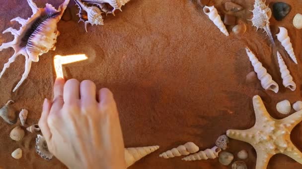 Hand drawing Egypt symbol in the sand. Beach background. Top view — Stock Video