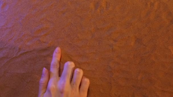 Hand zeichnet Pfeil-Symbol in den Sand. Strand Hintergrund. Ansicht von oben — Stockvideo