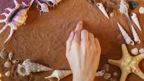 手に砂の数 9 9 シンボルを描画します。ビーチの背景。トップ ビュー — ストック動画
