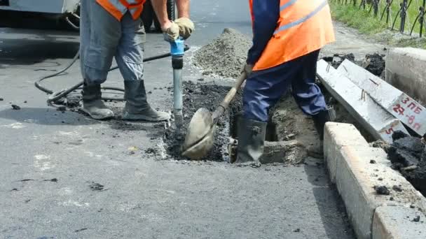 Pavimentación de carreteras. Trabajadores colocando asfalto masivo de piedra durante las obras de reparación de la calle . — Vídeos de Stock