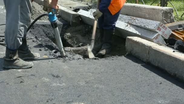 Pavimentación de carreteras. Trabajadores colocando asfalto masivo de piedra durante las obras de reparación de la calle . — Vídeo de stock