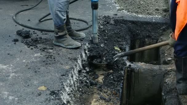 Pavimentación de carreteras. Trabajadores colocando asfalto masivo de piedra durante las obras de reparación de la calle . — Vídeos de Stock