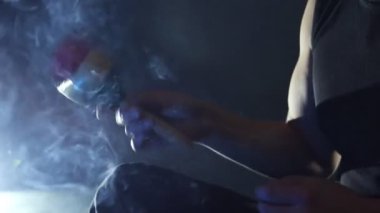 Erkek el marakas (Shakers), oynarken tütsü karanlık bir arka plan üzerinde manevi müzik akşam.