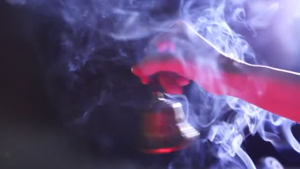 Handglocke auf dunkelblauem Hintergrund mit Rotlichtfilter und Weihrauch — Stockvideo