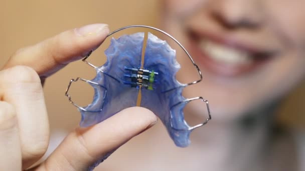 Hermosa chica sonriente con retenedor para los dientes, primer plano . — Vídeo de stock