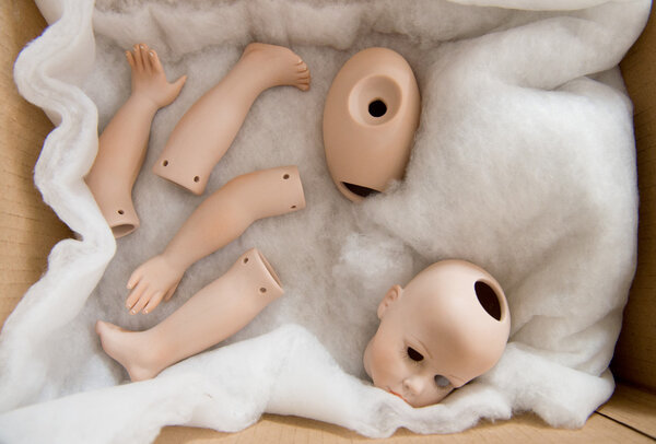Doll body parts in a box