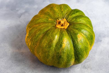 Gri arka planda balkabağı ve balkabağı tohumları. Sonbahar öğle yemeği konsepti. Ahşap bir arka planda. Sağlıklı beslenme ürünü. Boşluğu kopyala.