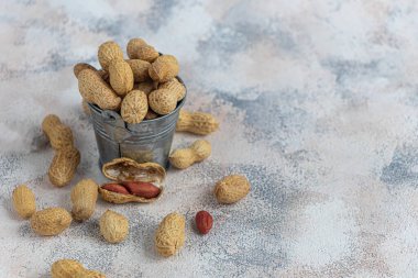 Fıstık. Faydalı vitaminler ve mineraller içeriyor. Gri bir arka planda. Boşluğu kopyala.