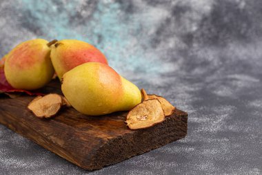 Armutlar hafif arka planda. Sonbahar konsepti. Yakınlarda kurutulmuş armut ve fındık var. Boşluğu kopyala.