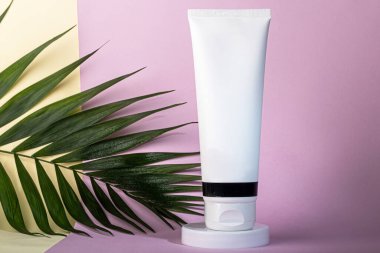 Krema için beyaz plastik şişeler. Whatman gazetesinin çok renkli arka planında. Boşluğu kopyala.