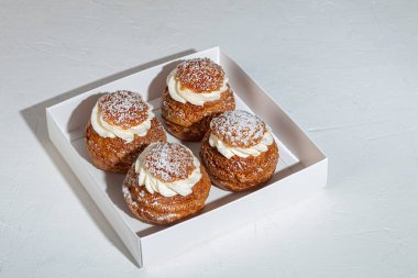 Rum baba, arka planda tereyağlı krema. Eve teslim. Şenlik konsepti. Karantinaya alın. Boşluğu kopyala.
