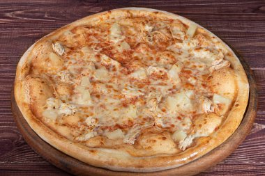 Pastırma peynirli pizza ve ahşap bir tabakta peynir ve vişneli domates. Ahşap bir arka planda. Yukarıdan görüntüle.