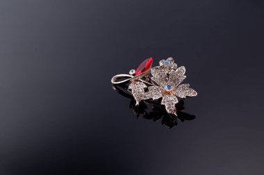 Bijouterie ve karanlık bir arka planda mücevher. Broşlar, saç tokaları, küpeler ve kolyeler. Boşluğu kopyala