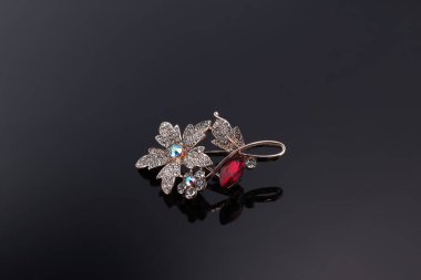 Bijouterie ve karanlık bir arka planda mücevher. Broşlar, saç tokaları, küpeler ve kolyeler. Boşluğu kopyala