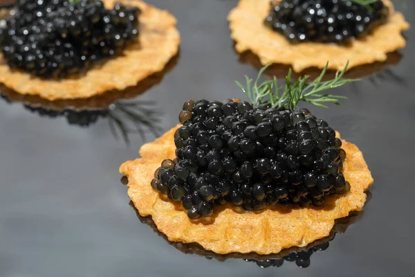 Caviar negro en tartaletas sobre un fondo oscuro. Concepto de comida saludable. — Foto de Stock