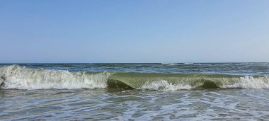 Deniz Burnu. Suyun masmavi rengi, kıyıda köpüren dalgalar. Seçici odak.