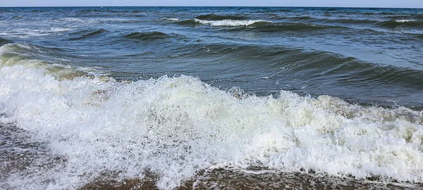 海景。碧绿的水色,浪花飘扬在岸边.有选择的重点. — 图库照片