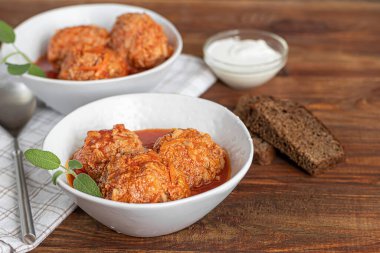 Ahşap bir arka planda adaçayı ve maydanoz yapraklı köfteler. Ev yapımı öğle yemeği. Boşluğu kopyala.