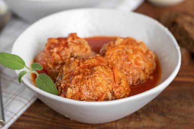 Ahşap bir arka planda adaçayı ve maydanoz yapraklı köfteler. Ev yapımı öğle yemeği. Boşluğu kopyala.