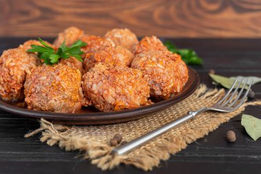 Ahşap bir arka planda adaçayı ve maydanoz yapraklı köfteler. Ev yapımı öğle yemeği. Boşluğu kopyala.