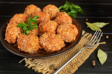 Ahşap bir arka planda adaçayı ve maydanoz yapraklı köfteler. Ev yapımı öğle yemeği. Boşluğu kopyala.