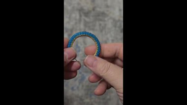 Hafif arka planda tohum boncukları ve cam boncuklardan yapılmış el yapımı yuvarlak küpeler. Boşluğu kopyala