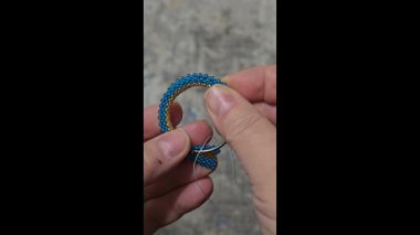 Hafif arka planda tohum boncukları ve cam boncuklardan yapılmış el yapımı yuvarlak küpeler. Boşluğu kopyala