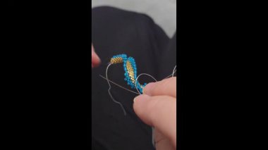 Hafif arka planda tohum boncukları ve cam boncuklardan yapılmış el yapımı yuvarlak küpeler. Boşluğu kopyala