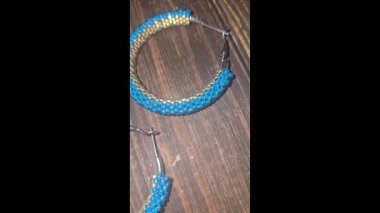 Hafif arka planda tohum boncukları ve cam boncuklardan yapılmış el yapımı yuvarlak küpeler. Boşluğu kopyala