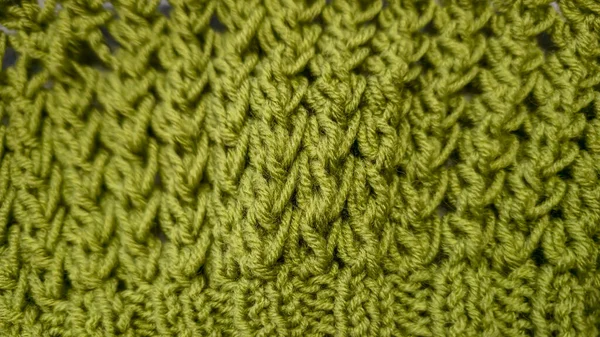 Örgü deseni kalın, yeşil iplik kullanıyor. Örgü kazakları, şapkalar ve diğer örgü eşyalar için detaylar. El Sanatları.